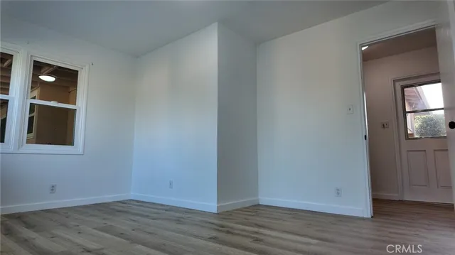 a dining room with furniture potted plants and wooden floor