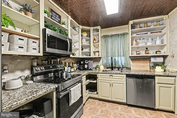 a kitchen with stainless steel appliances granite countertop a stove and cabinets