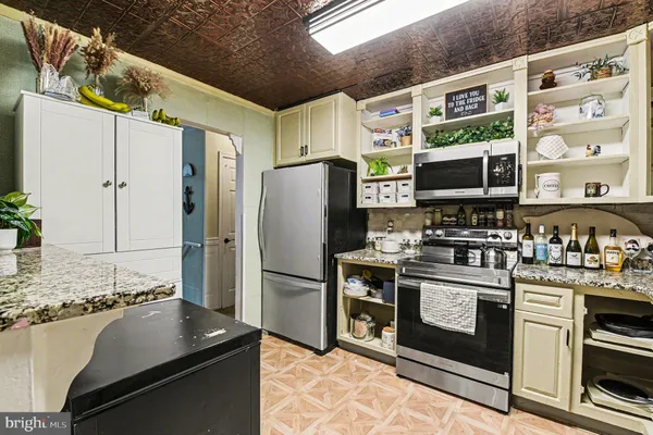 a kitchen with stainless steel appliances granite countertop a stove a refrigerator and a sink