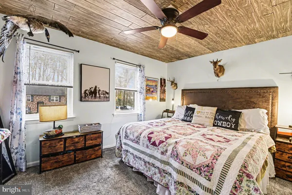 a bedroom with a bed window and dresser