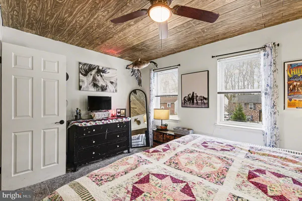 a bedroom with a bed dresser and a window