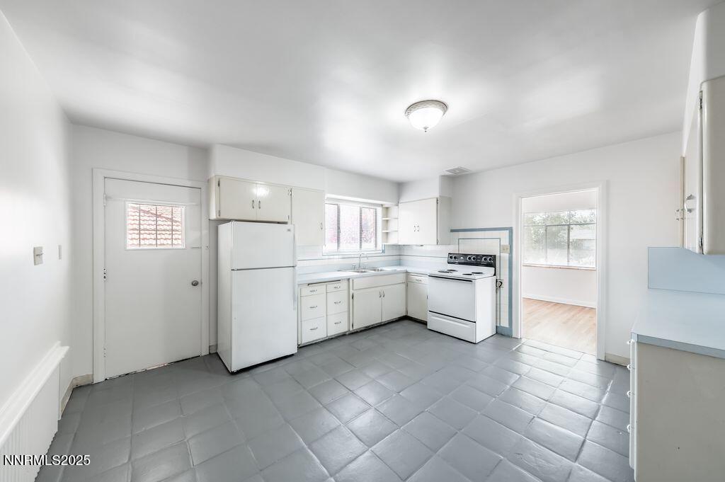 680 Edelweiss Street Reno, NV 89502 - Photo 9 of 29 a kitchen with white cabinets and white appliances