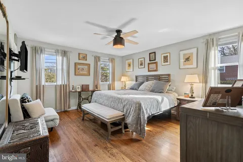 a spacious bedroom with a bed and wooden floor