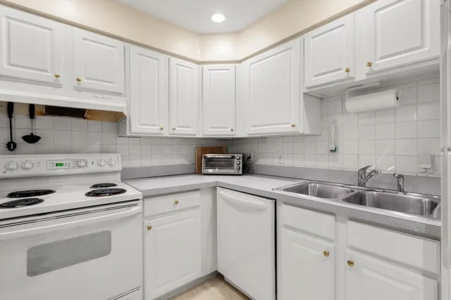 a kitchen with cabinets appliances a sink and a counter