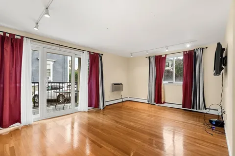 a view of a livingroom with wooden floor and a flat screen tv