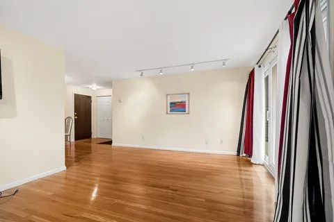 a view of a room with wooden floor and a window