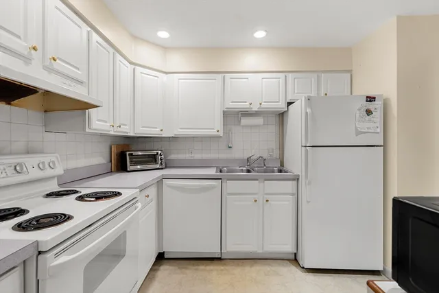 a kitchen with a white stove top oven and white cabinets