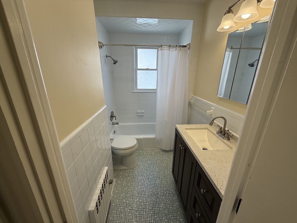 15 Chauncey Street, Unit 2 Watertown, MA 02472 - Photo 12 of 16 a bathroom with a sink a toilet and a mirror