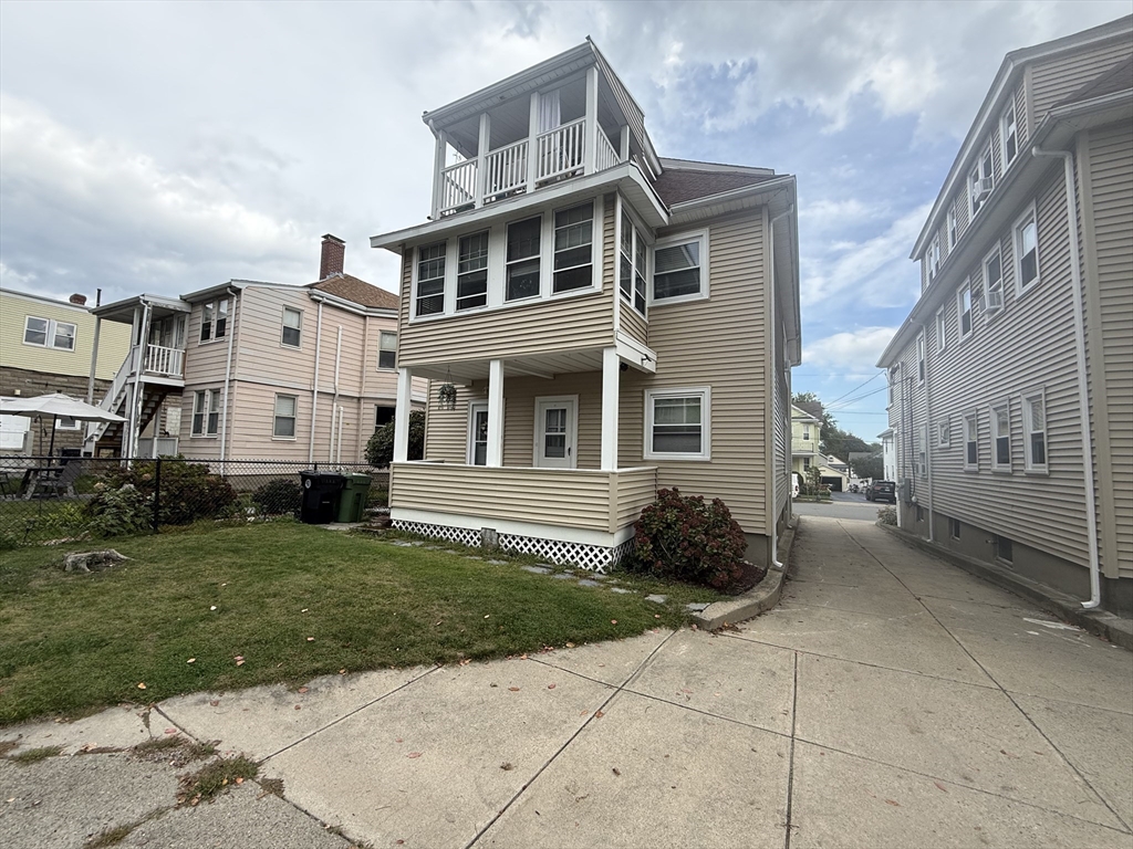 15 Chauncey Street, Unit 2 Watertown, MA 02472 - Photo 15 of 16 a front view of a house with a garden