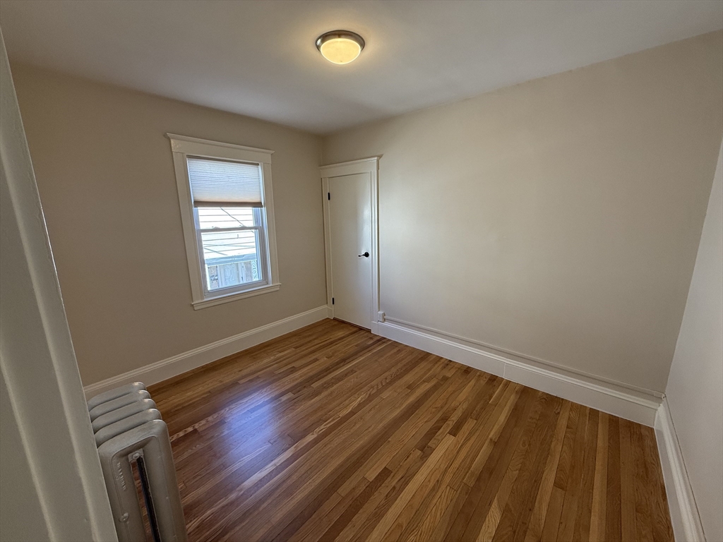 15 Chauncey Street, Unit 2 Watertown, MA 02472 - Photo 9 of 16 a view of an empty room with wooden floor and a window