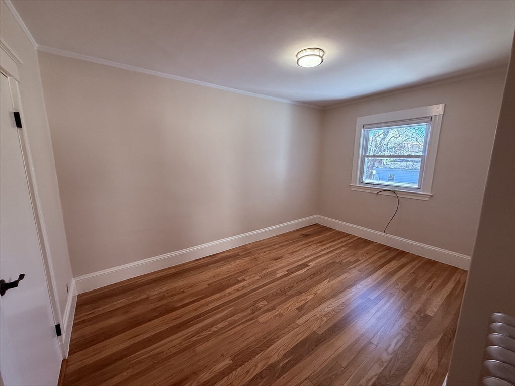 15 Chauncey Street, Unit 2 Watertown, MA 02472 - Photo 10 of 16 a view of empty room with wooden floor and fan