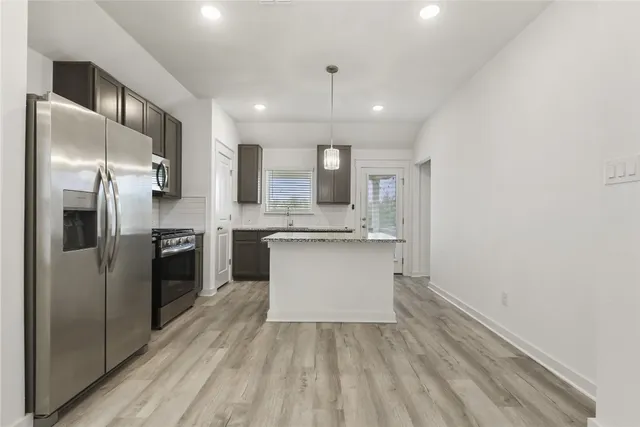a large kitchen with a refrigerator and a stove top oven