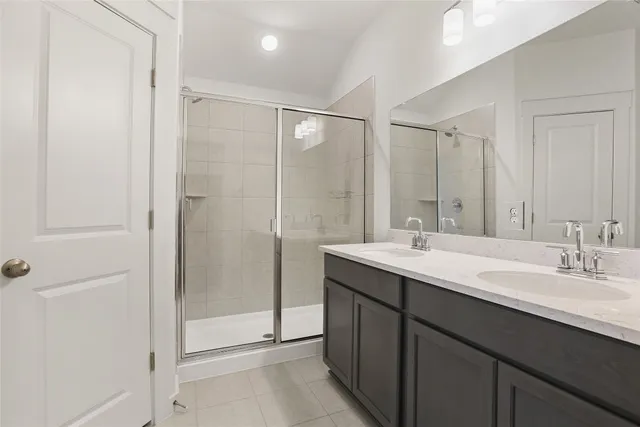 a bathroom with a double vanity sink mirror and shower