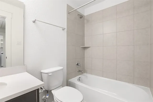 a white toilet sitting next to a bath tub