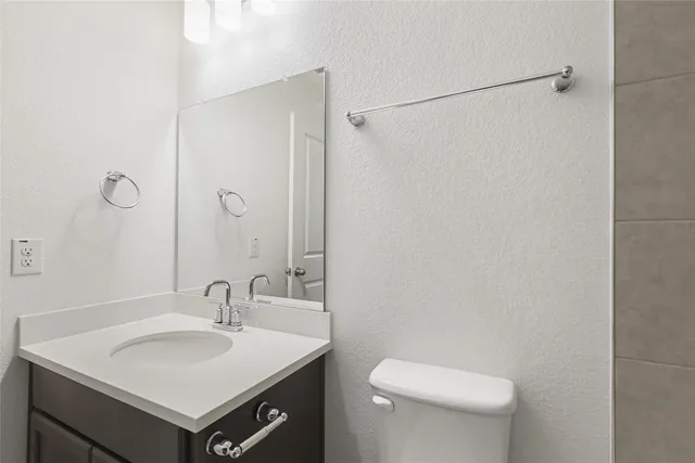 a bathroom with a sink toilet and mirror