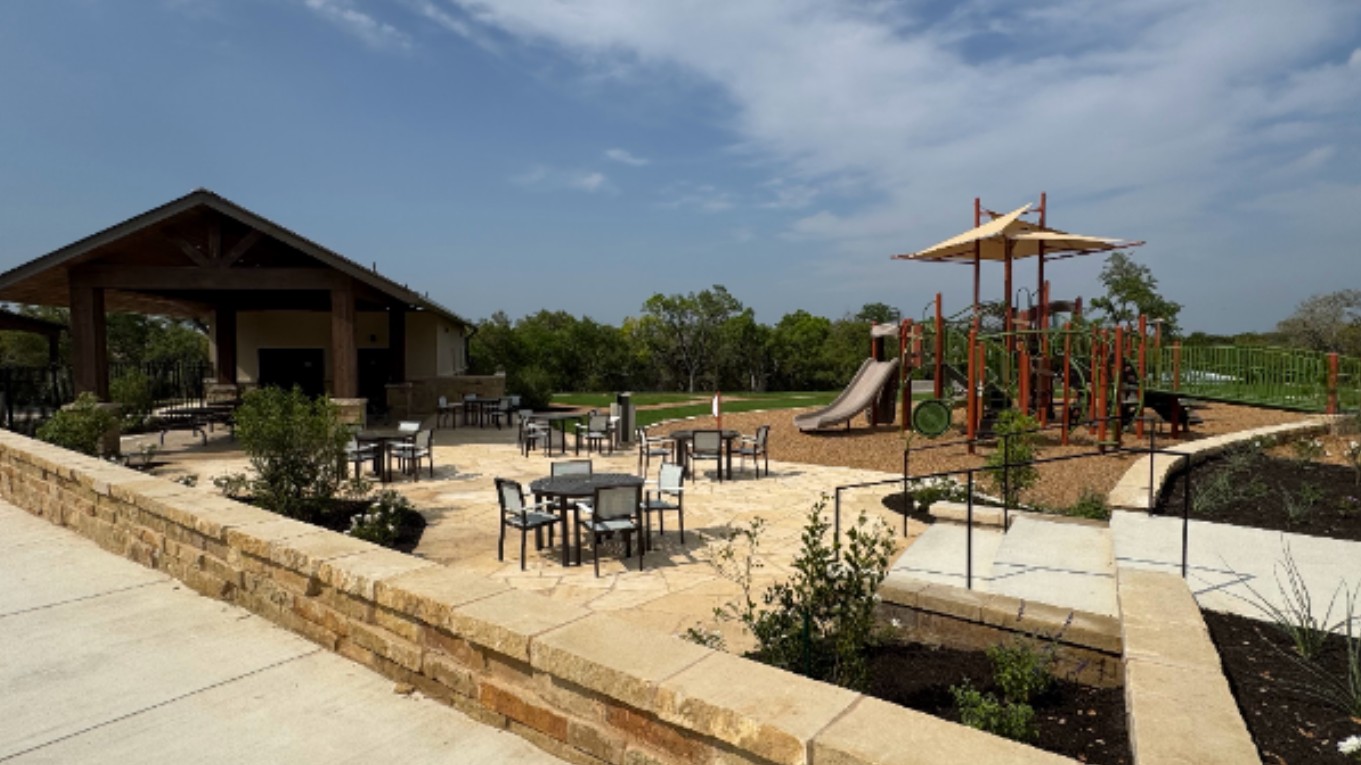 2340 Sawdust Drive Georgetown, TX 78633 - Photo 34 of 40 a view of a patio with a dining table and chairs under an umbrella with large trees