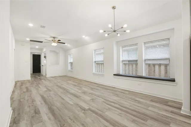 a view of an empty room with window and cabinet