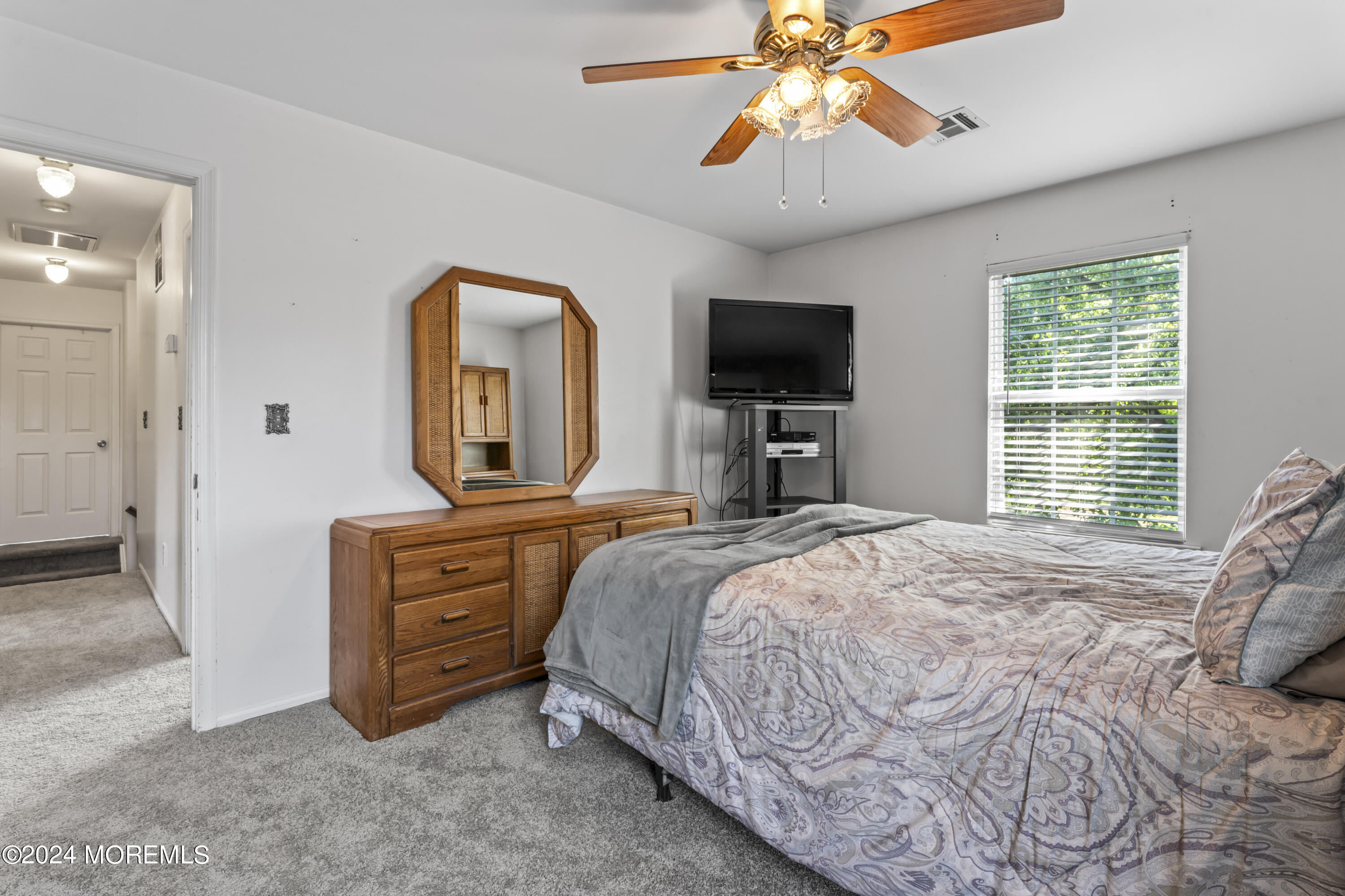 58 Lorelei Drive Howell, NJ 07731 - Photo 24 of 37 a bedroom with a bed a chandelier and a flat tv screen