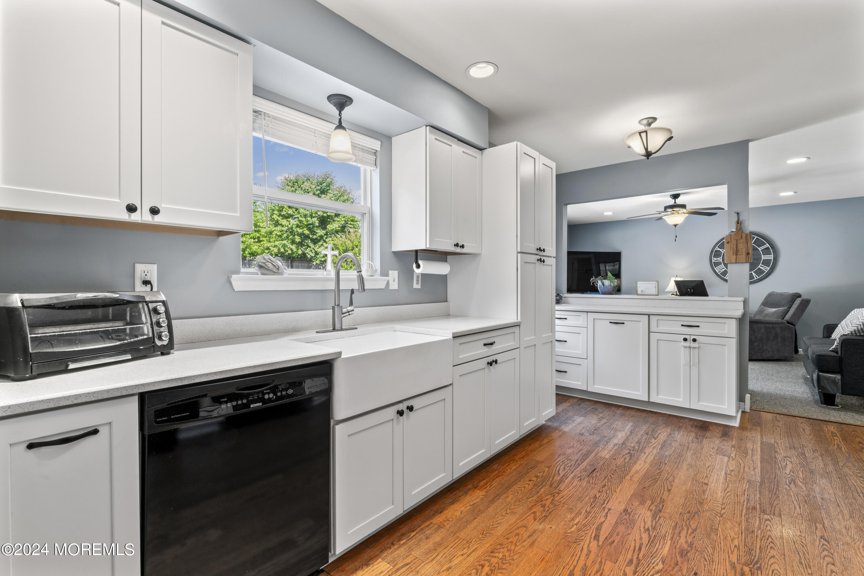 58 Lorelei Drive Howell, NJ 07731 - Photo 9 of 37 a kitchen with a sink dishwasher stove and white cabinets with wooden floor
