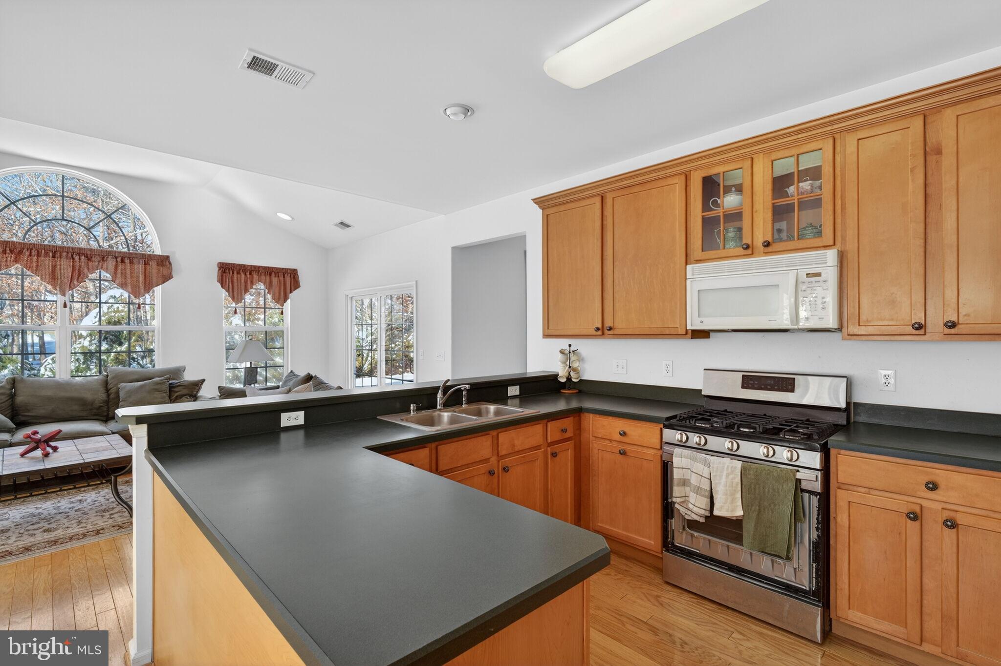 76 Portland Street Barnegat, NJ 08005 - Photo 18 of 47 a kitchen with a sink a counter top space and living room filled with furniture