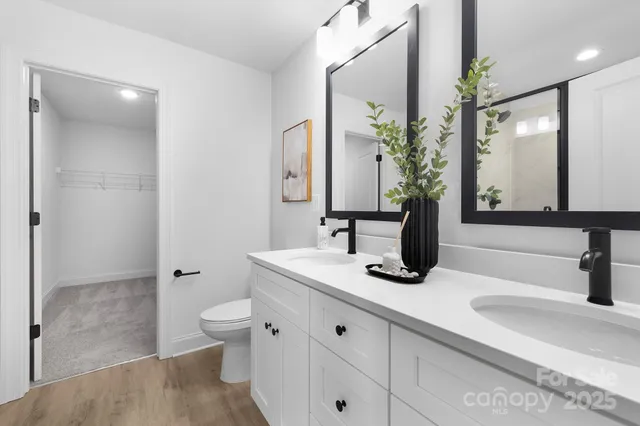 a bathroom with a double vanity sink toilet and shower