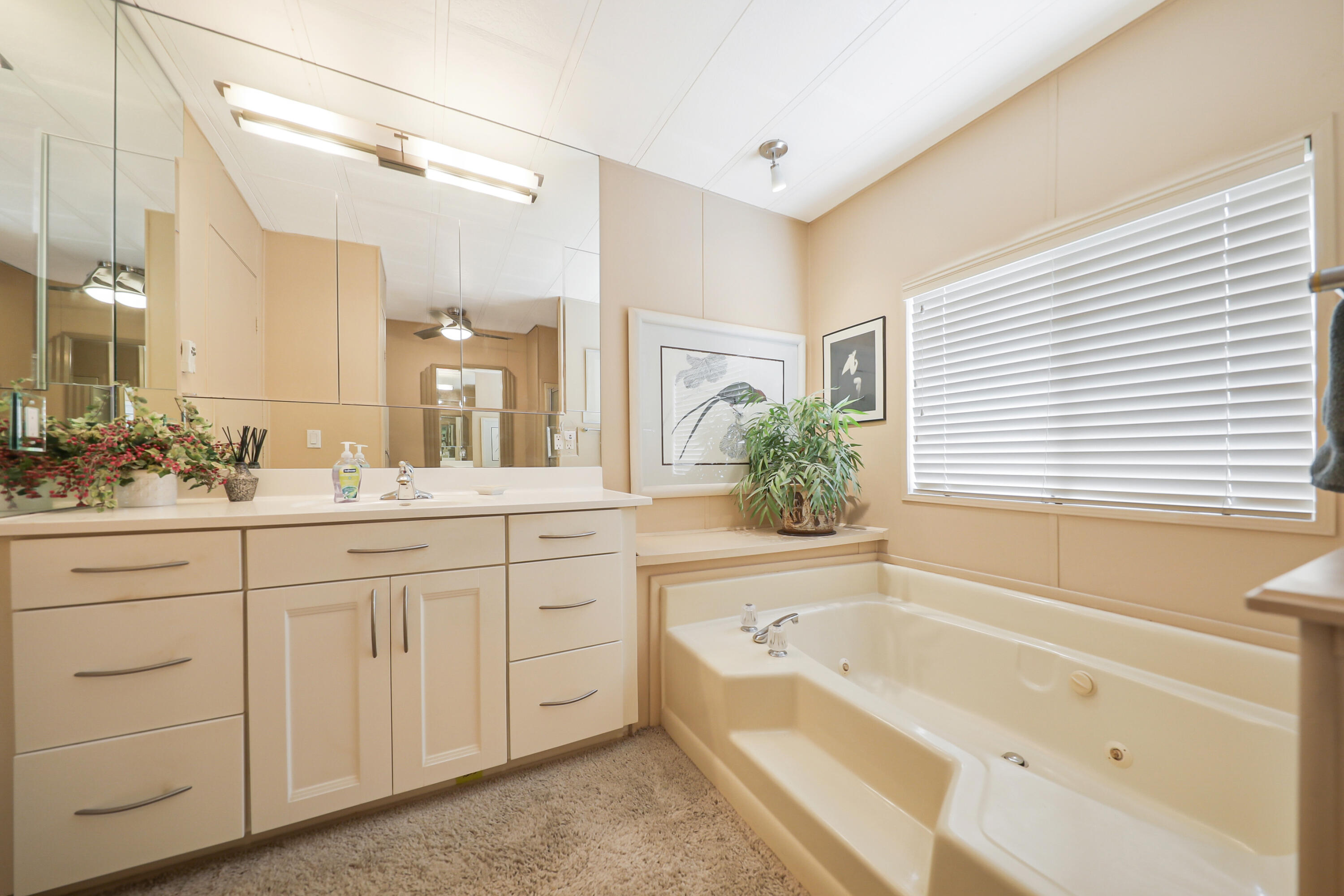 49305 Highway 74, Unit 86 Palm Desert, CA 92260 - Photo 20 of 31 a bathroom with a granite countertop sink mirror bathtub and next to a window