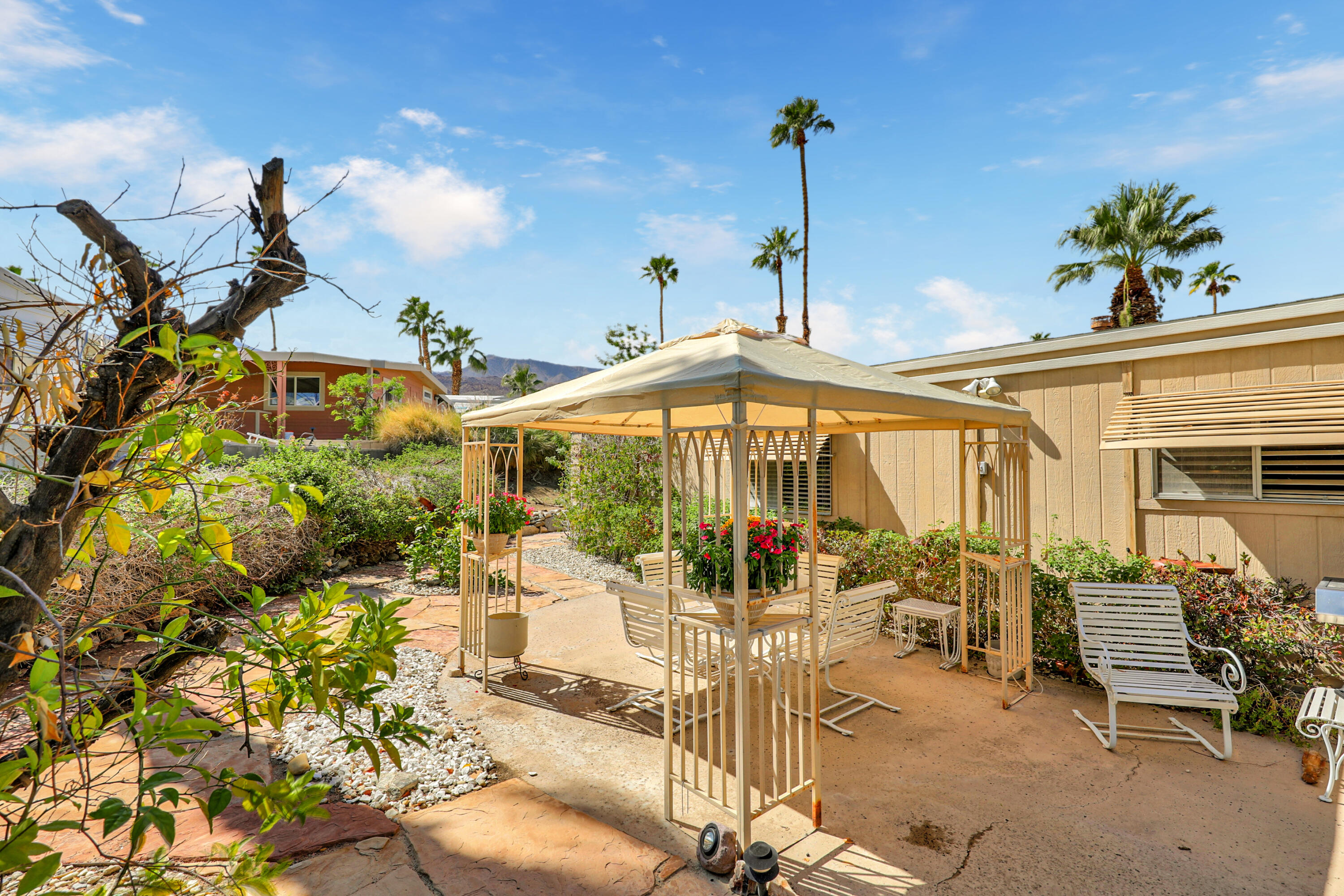 49305 Highway 74, Unit 86 Palm Desert, CA 92260 - Photo 4 of 31 a view of a patio with table and chairs potted plants