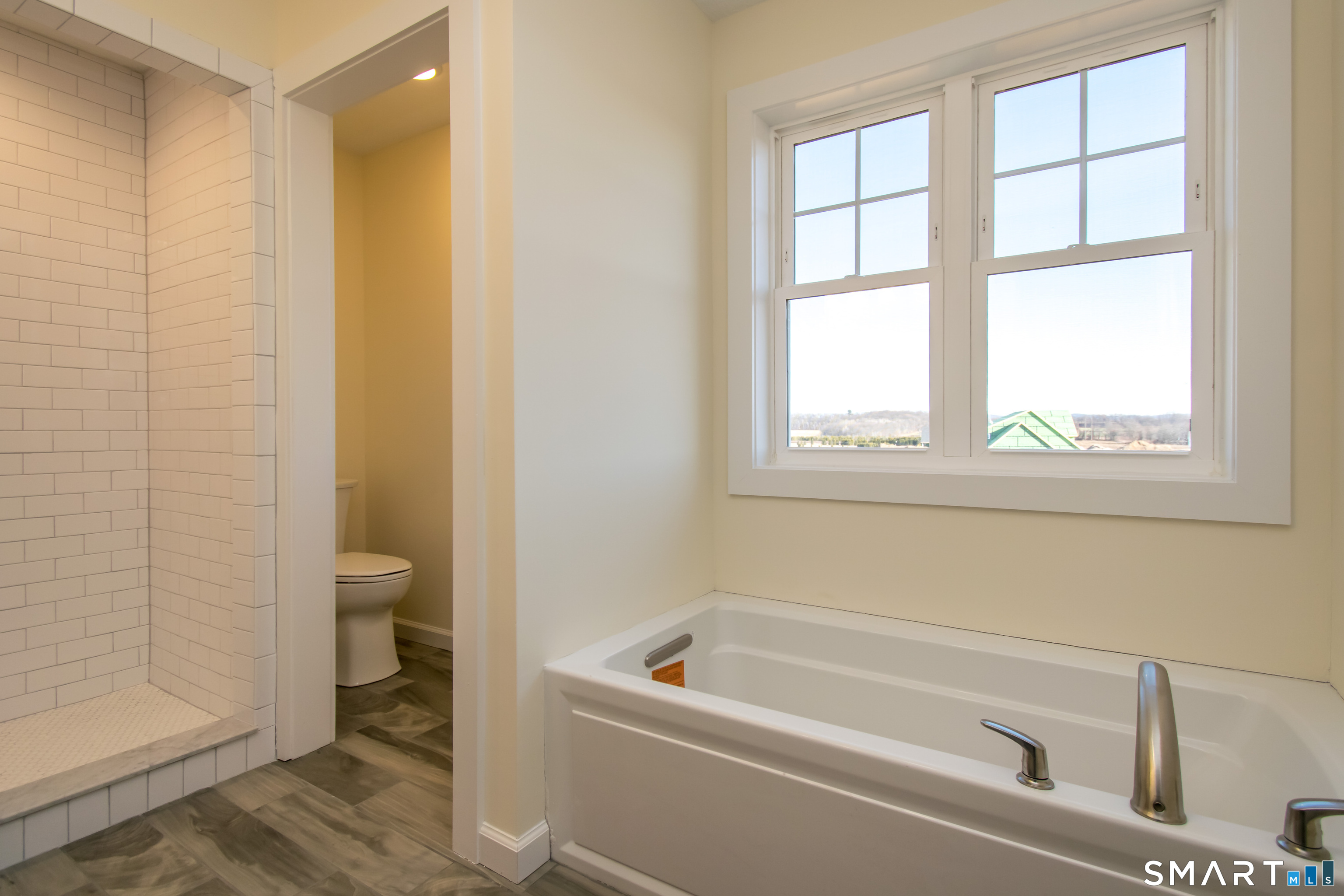318 Capen Street Windsor, CT 06095 - Photo 25 of 30 a bathroom with a bathtub a window and a shower
