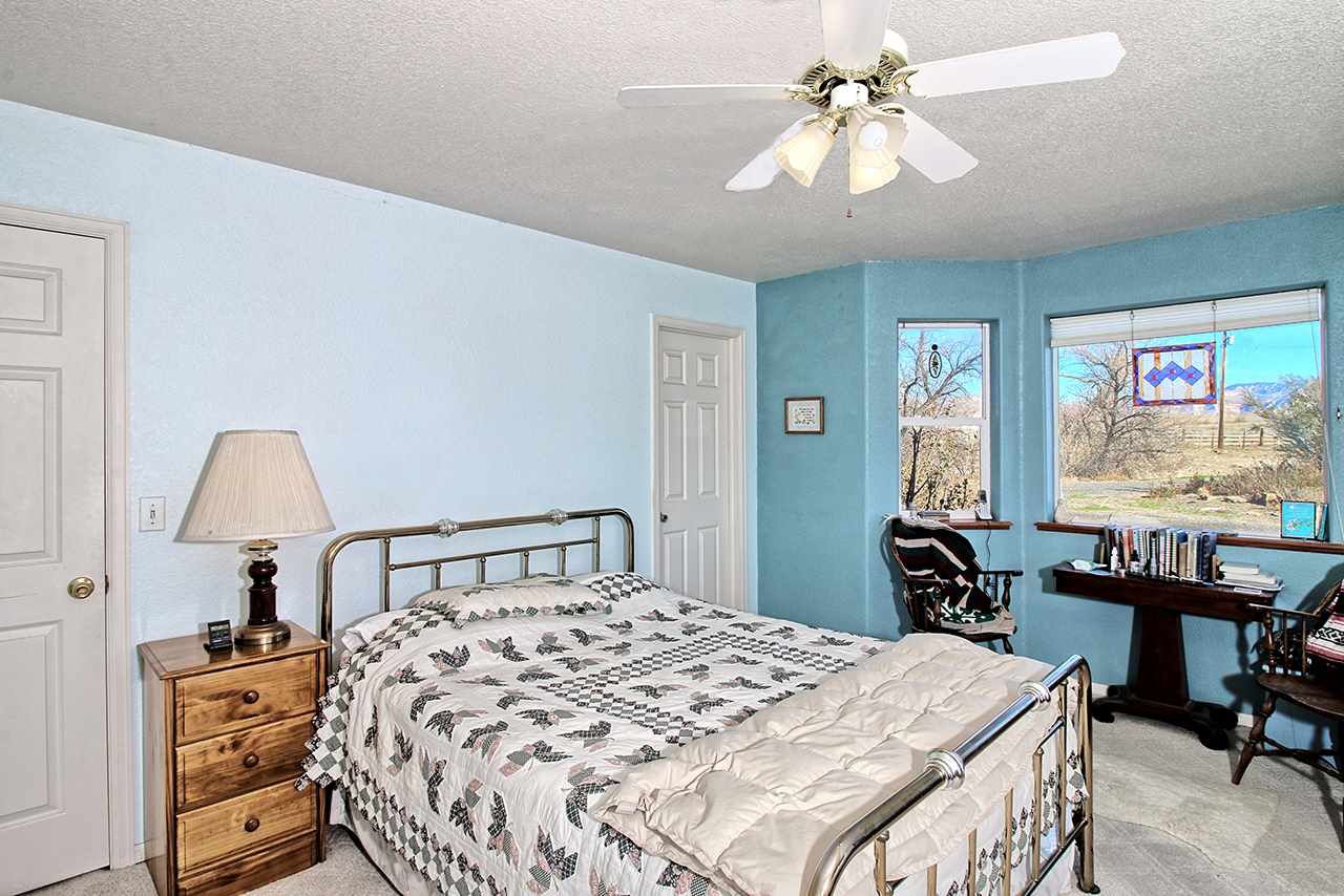 1515 19 Road Fruita, CO 81521 - Photo 34 of 42 a bedroom with a bed and a chandelier