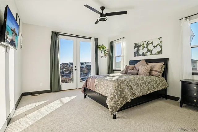 a spacious bedroom with a bed and a flat tv screen