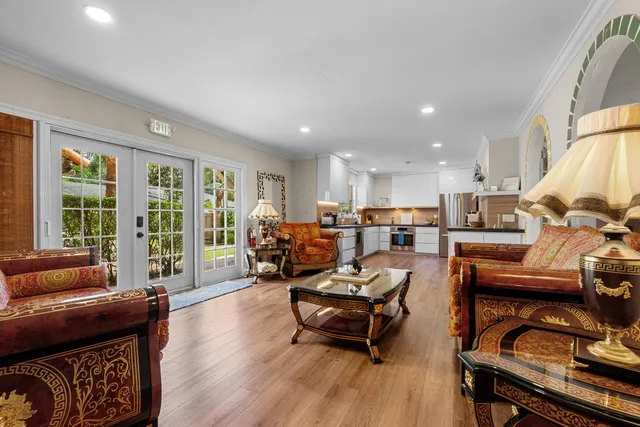 a view of a dining room with furniture a chandelier and wooden floor