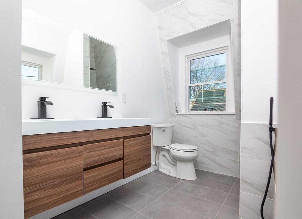 84 Dudley Street Medford, MA 02155 - Photo 17 of 27 a bathroom with a toilet sink and mirror