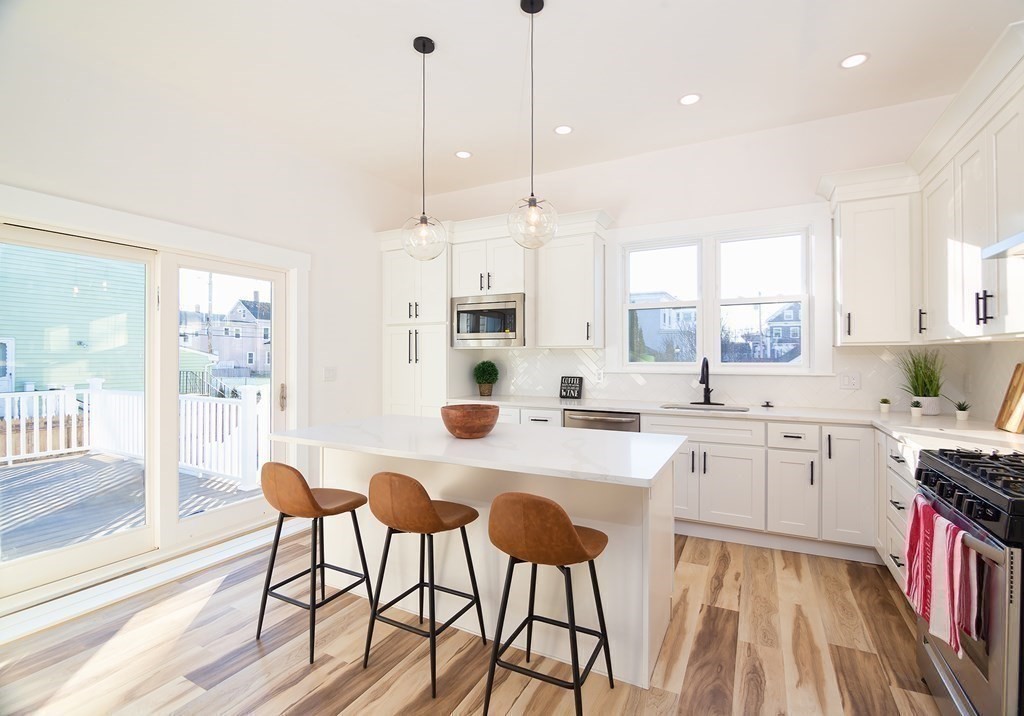 84 Dudley Street Medford, MA 02155 - Photo 7 of 27 a large kitchen with sink a refrigerator and chairs
