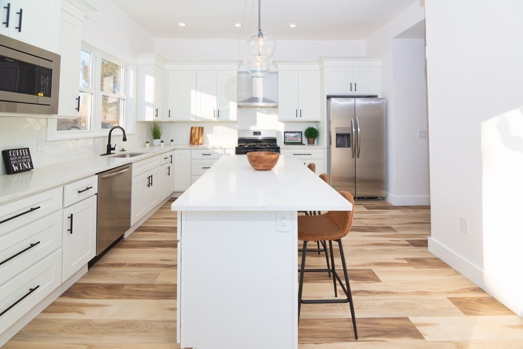 84 Dudley Street Medford, MA 02155 - Photo 8 of 27 a kitchen with white cabinets and stainless steel appliances