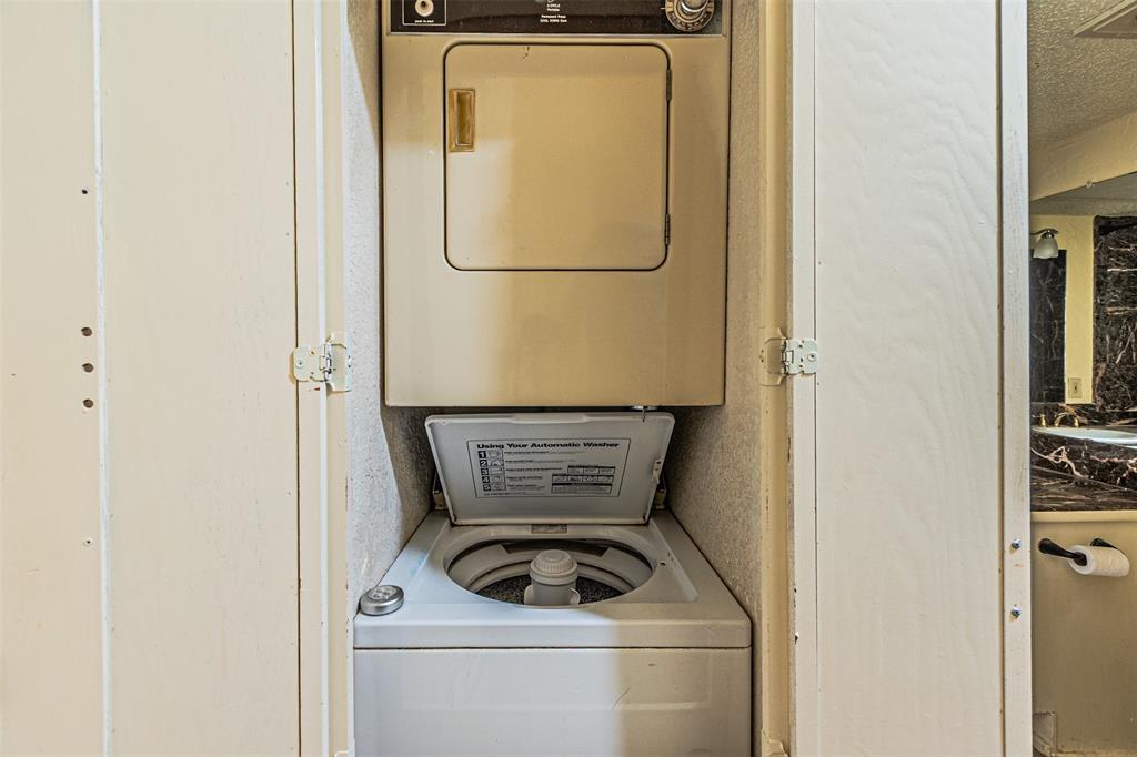 5590 Spring Valley Road, Unit C205 Dallas, TX 75254 - Photo 15 of 25 Laundry area featuring stacked washer / drying machine