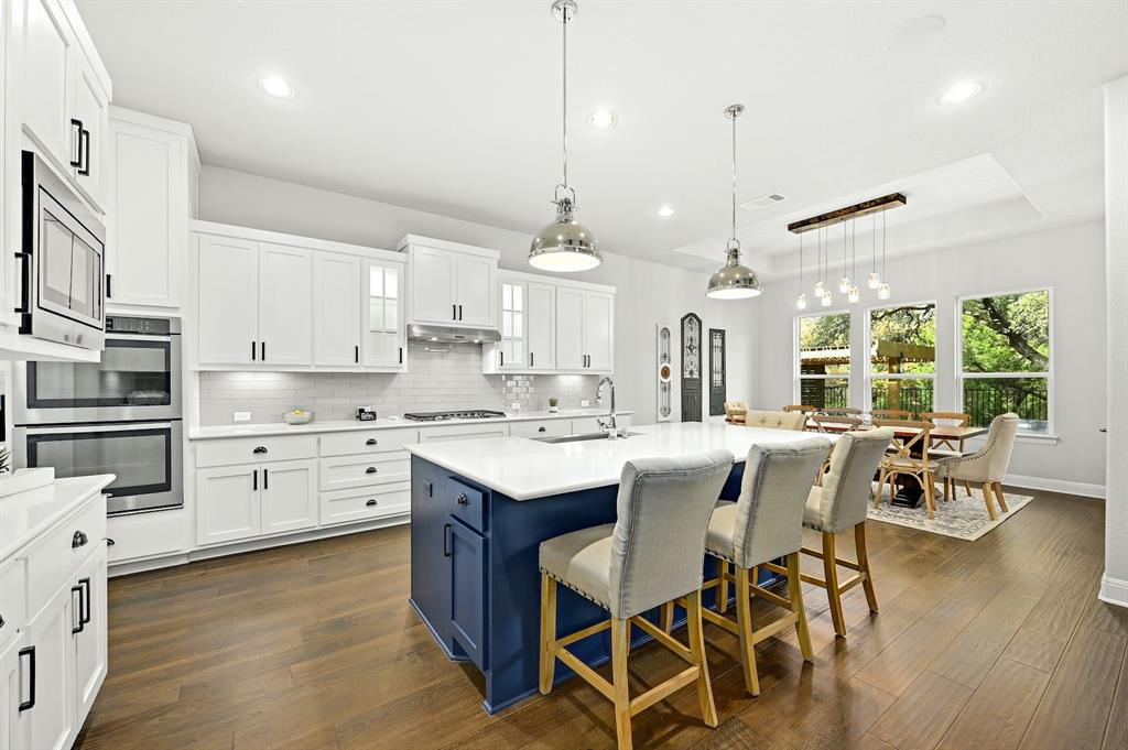 629 Germander Road Leander, TX 78641 - Photo 8 of 32 Culinary creativity comes alive in this bright kitchen, offering a blue island with seating, ample counter space, and modern appliances.