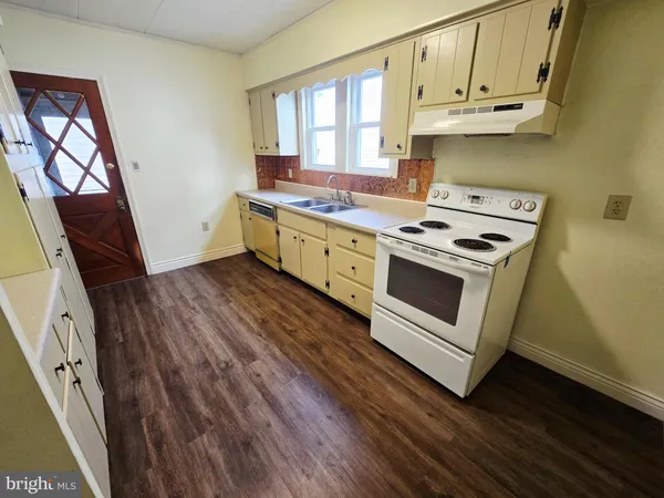 a kitchen with wooden floors and white appliances