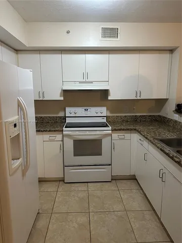 a kitchen with cabinets and white appliances