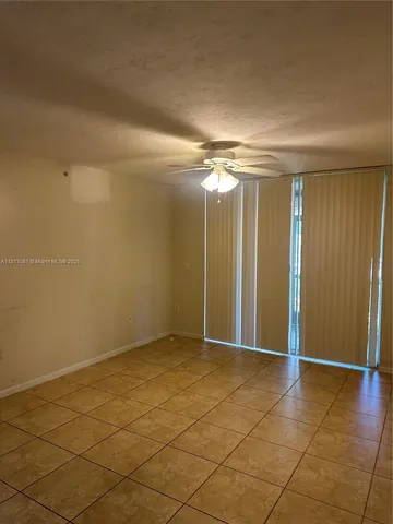 an empty room with fan and entrance