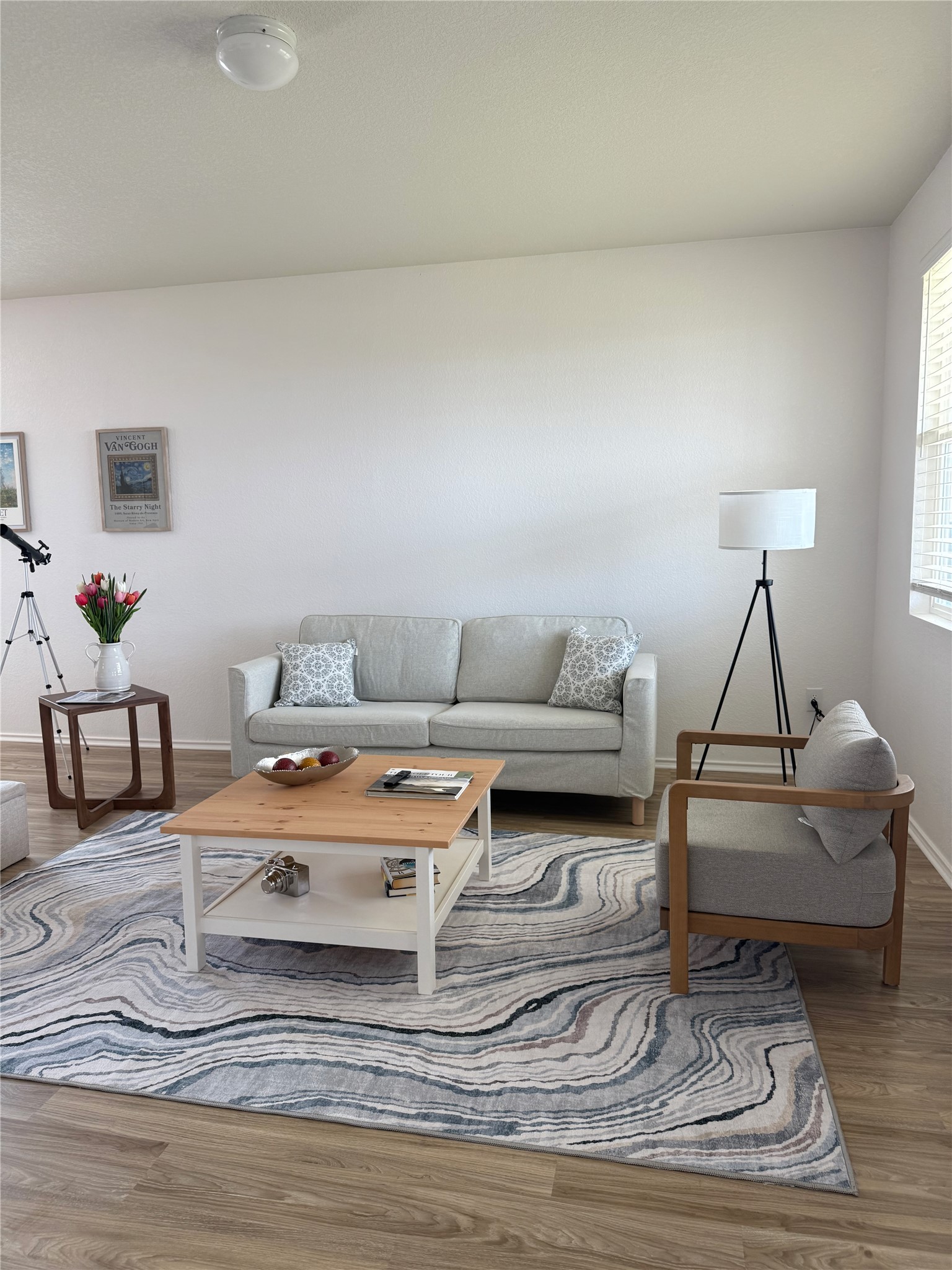 14907 Retha Pass Austin, TX 78725 - Photo 2 of 14 Smooth walls and classic wood-look flooring establish a relaxed tone in this comfortable living area.
