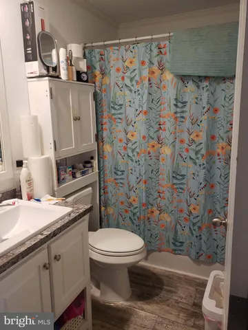 a bathroom with a granite countertop toilet sink and mirror
