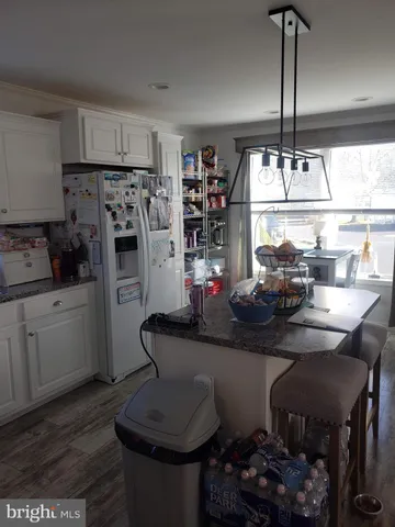 a kitchen with stainless steel appliances a dining table chairs and a refrigerator