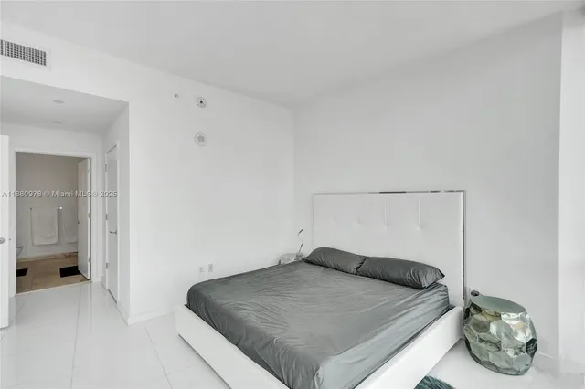 a bedroom with a large bed and a large window