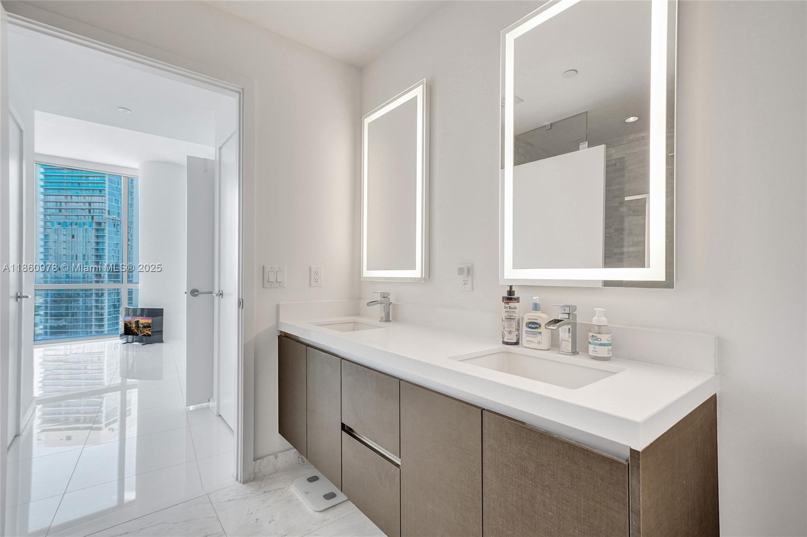 851 Northeast 1st Avenue, Unit 3800 Miami, FL 33132 - Photo 27 of 29 a bathroom with a sink and a mirror