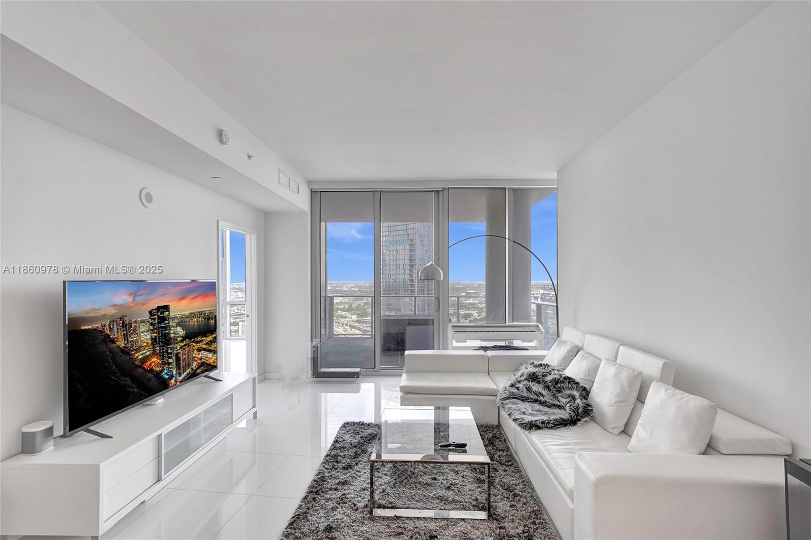 851 Northeast 1st Avenue, Unit 3800 Miami, FL 33132 - Photo 8 of 29 a living room with furniture and a flat screen tv