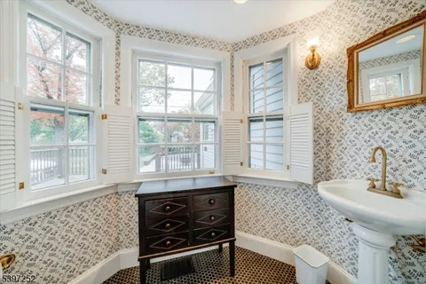 a bathroom with a sink a toilet and a large window