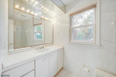 a bathroom with a sink mirror and a window