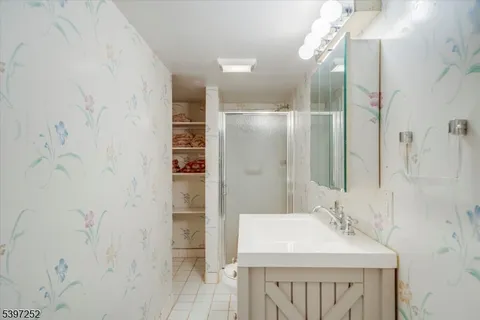a bathroom with a sink shower and a mirror