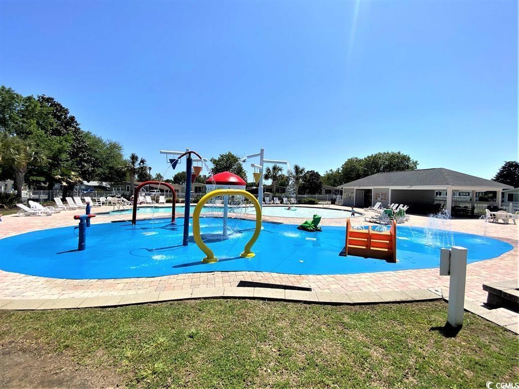 1672 Falcon Surfside Beach, SC 29575 - Photo 25 of 26 Community pool with a water play area and a lawn