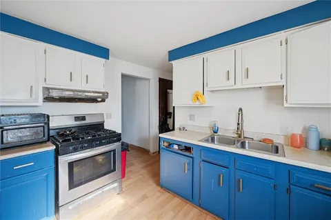 a kitchen with stainless steel appliances a stove a sink and a refrigerator